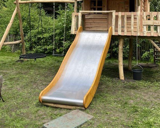Glijbaan van RVS bij Haroldspeelhuisjes, perfect voor veilig en duurzaam speelplezier in de buitenlucht