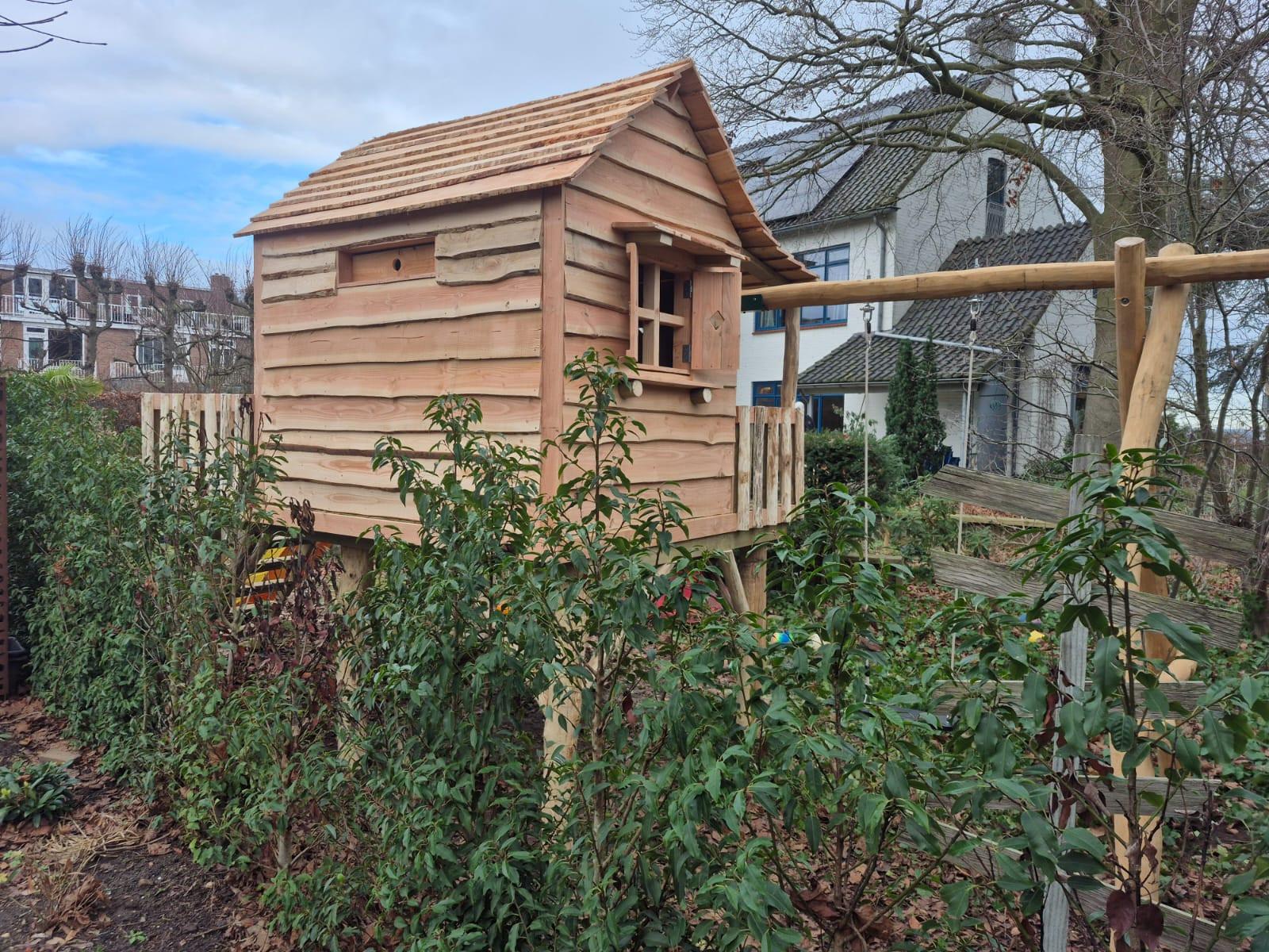Houten speelhuisje De Kastanje geplaatst in Nederlandse tuin