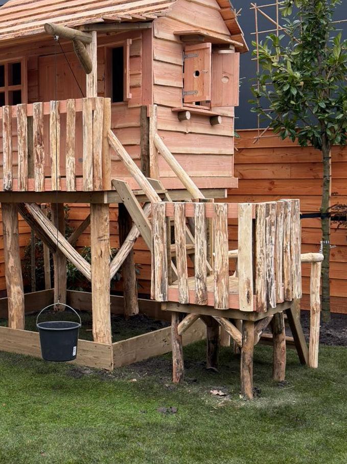 Trap met plateau gemonteerd aan een houten speelhuisje